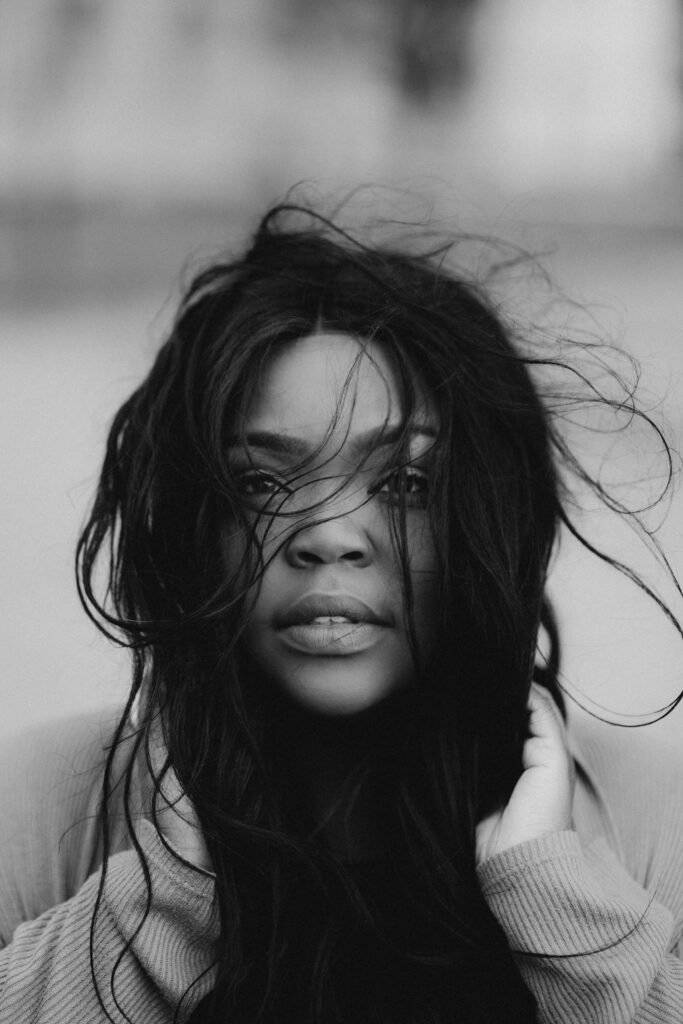 Black and white portrait of a woman with flowing hair and captivating gaze.